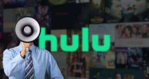 A person in a dress shirt and tie holds a megaphone in front of their face, standing in front of a blurred Hulu logo and background of various show posters.