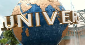 A large blue and gold globe with the word "UNIVERSAL" in bold white letters, located at the entrance of Universal Studios theme park.
