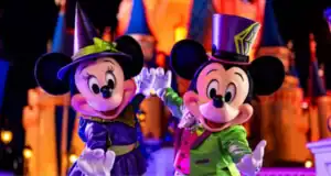 Mickey and Minnie Mouse in Halloween costumes in front of Cinderella Castle at Magic Kingdom near It’s a Small World at Disney World.